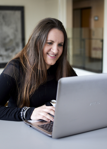 Kvinde foran computer på danskkursus